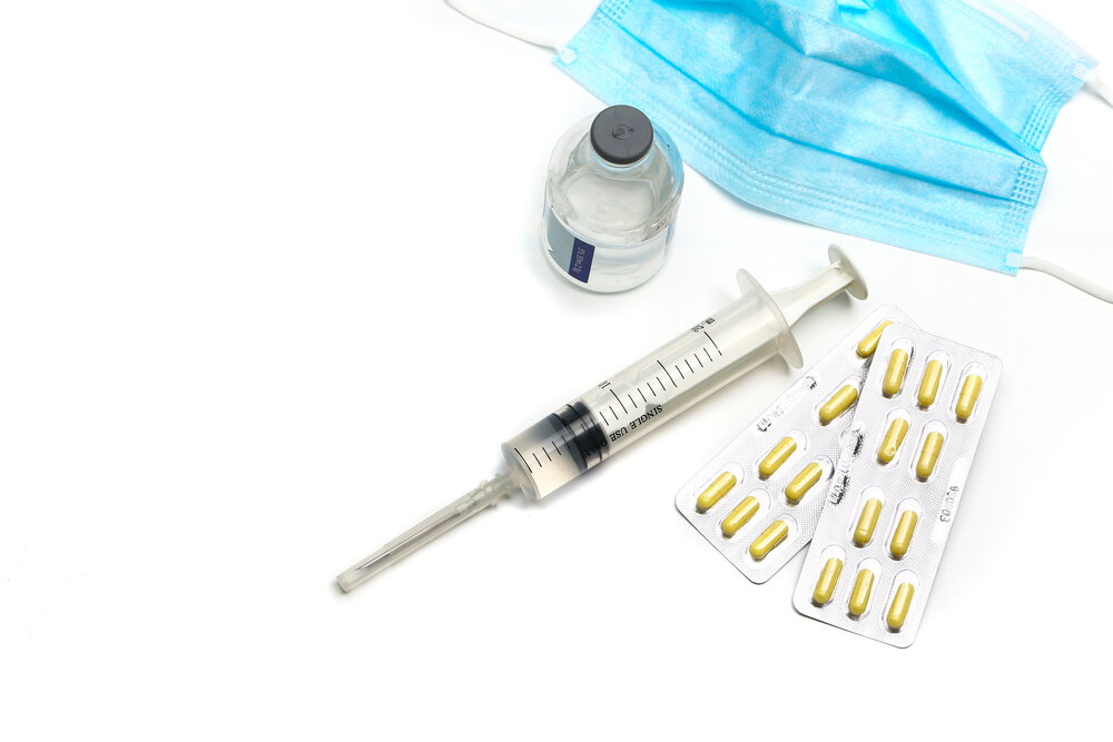 Syringe, capsules,and medical mask bottle on white background