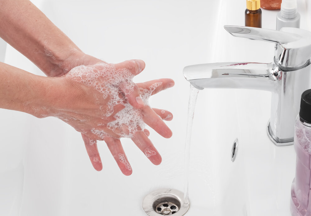 Woman washes her hands with soap under the tap in the bathroom. The concept of daily care, hygiene and health, the fight against the spread of the virus. Close-up, stop the virus.