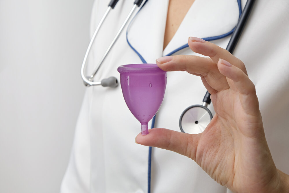 Menštruačný pohár v ruke lekára, koncepcia zdravia a ekológie.