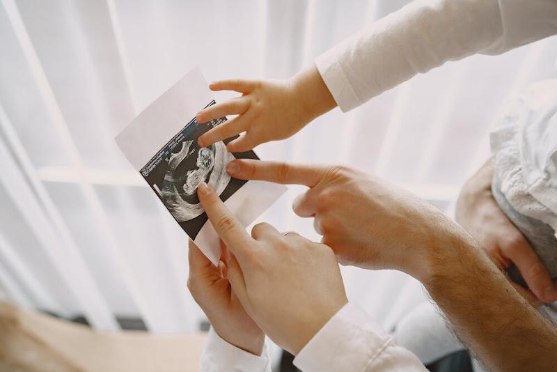 trojčlenná rodina ukazuje na fotografiu z ultrazvuku