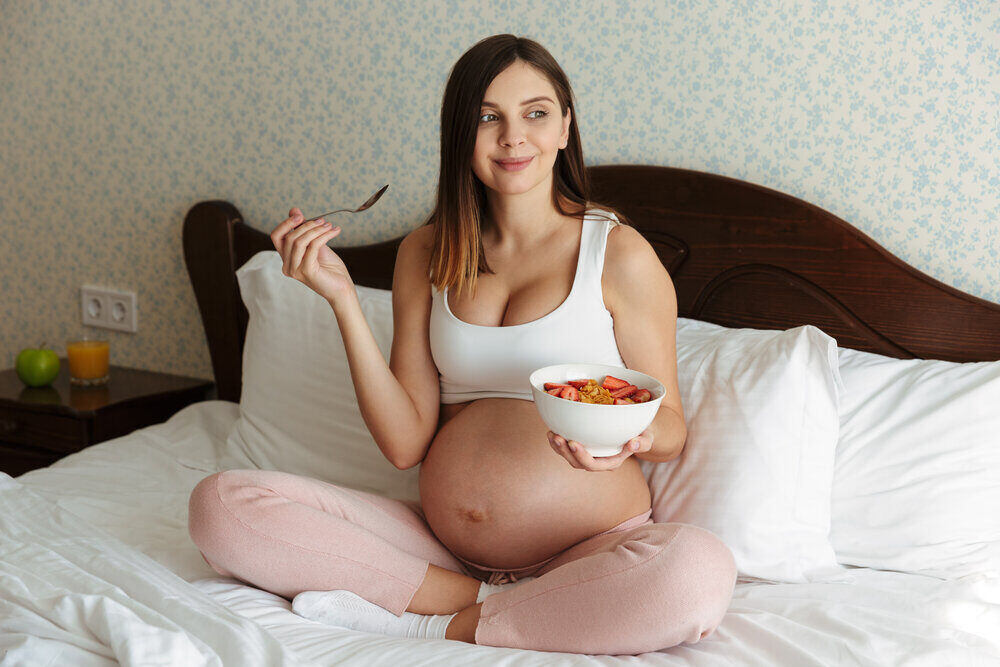 Portrét krásnej mladej tehotnej ženy, ktorá má zdravé raňajky