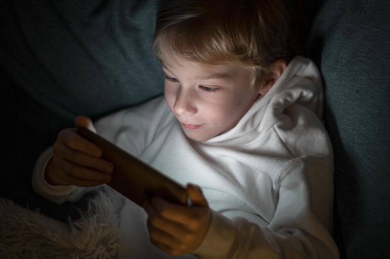 chlapec pozerá pred spaním do mobilu